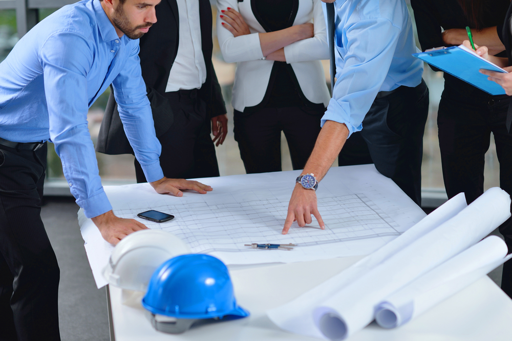 business people group on meeting and presentation  in bright modern office with construction engineer architect and worker looking building model and blueprint  plans-1